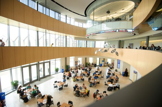 Students at tables inside the LSU Business Education Complex rotunda (E. J. Ourso College of Business)